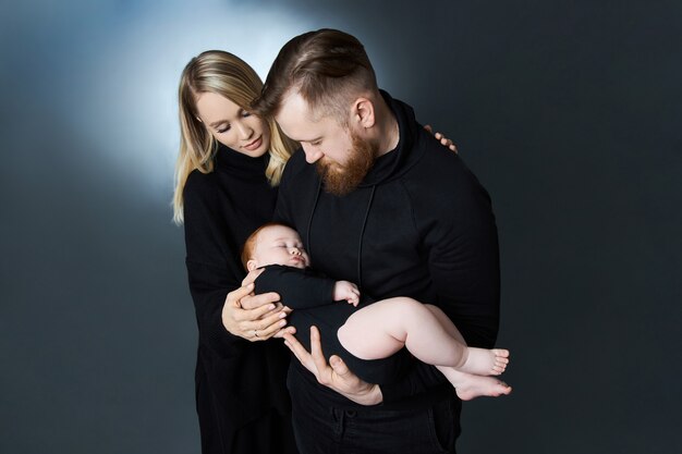 남자와 여자는 팔에 아기를 안고 있습니다.