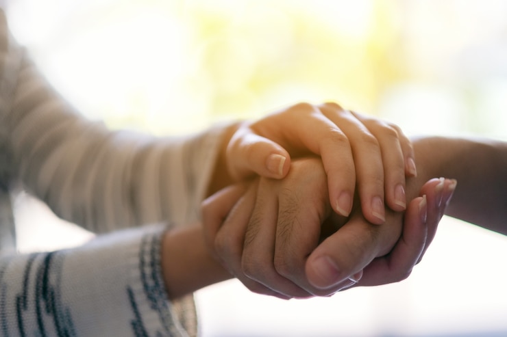 Photo a man and a woman holding each other hands for comfort and sympathy
