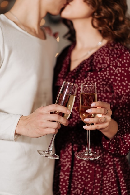 Uomo e donna che tengono bicchieri di champagne e si baciano