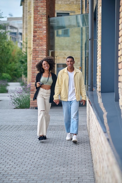 Man and woman holding hand walking on street