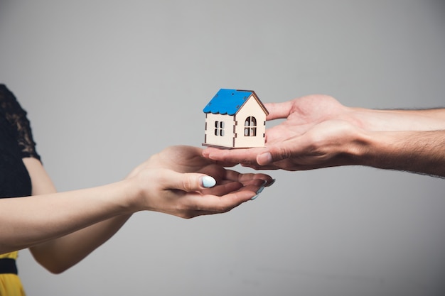 A man and a woman holding a house in their hands