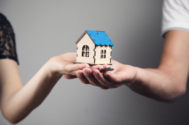 A man and a woman holding a house in their hands