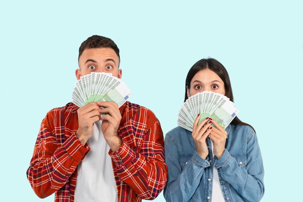 Foto uomo e donna che tengono i soldi davanti alle facce