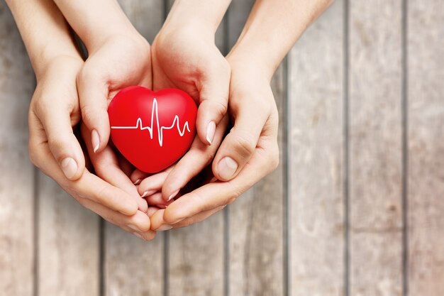 Man and woman holding red heart in