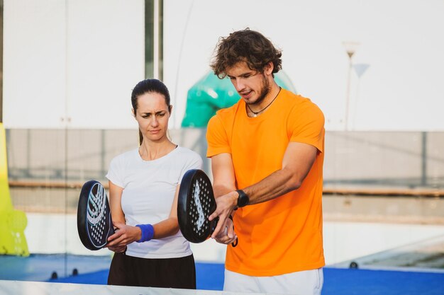 Photo man and woman holding tennis racket