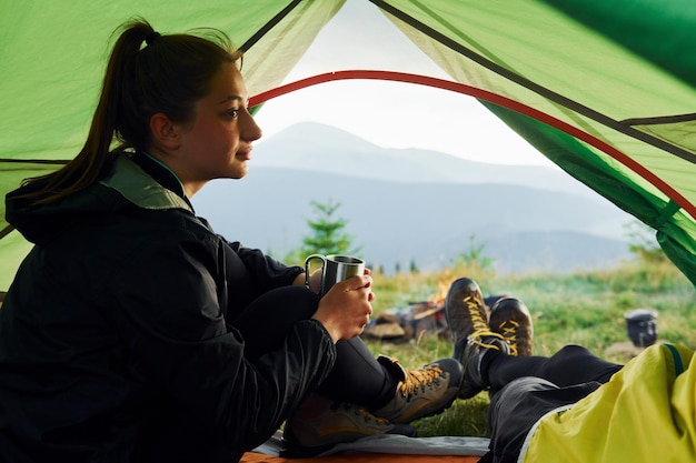 Foto uomo e donna all'interno della tenda insieme maestose montagne dei carpazi bellissimo paesaggio di natura incontaminata