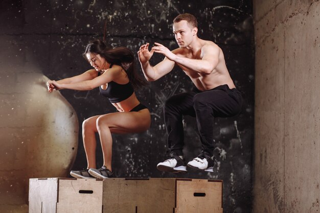 Man and woman jumping on fit box