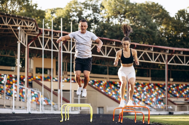 Man and woman jumping through barriers on stadium