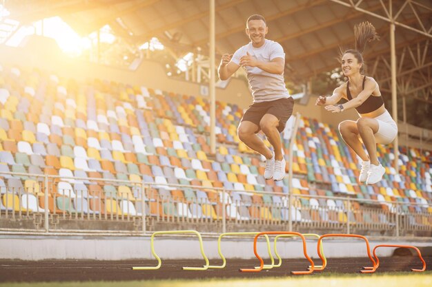 Man and woman jumping through barriers on stadium