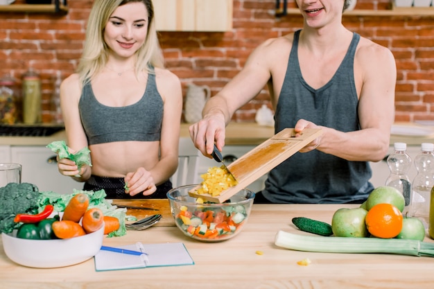 Man and woman in the kitchen at home. They prepare a tasty and healthy breakfast. They cook together. They are in the modern kitchen.