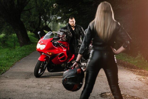 Man and woman in leather with sports motor bike