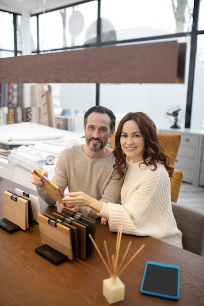 Man and woman in light sweaters looking happy