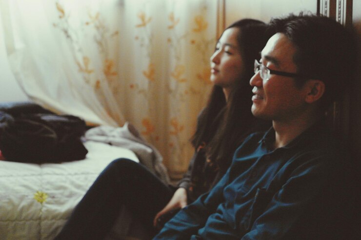Photo 男人和女人坐在家里看着别的地方