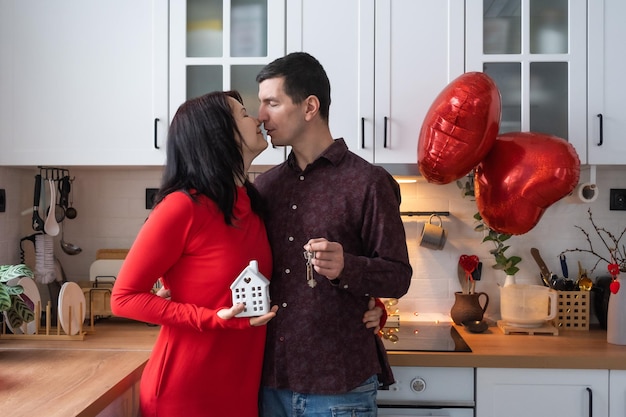 Man and woman in love date at home in kitchen with keys of house Valentine's Day happy couple love story Love nest mortgage relocation purchase real estate housing for young family