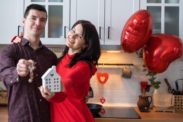 Man and woman in love date at home in kitchen with keys of house Valentine's Day happy couple love story Love nest mortgage relocation purchase real estate housing for young family