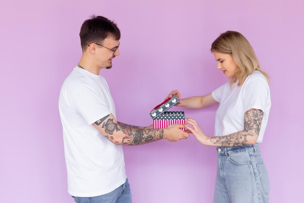 Man and woman in love at home celebrating with a gift box