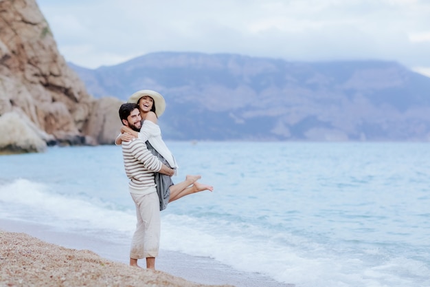 Man and woman in love uddle and kiss on the beach