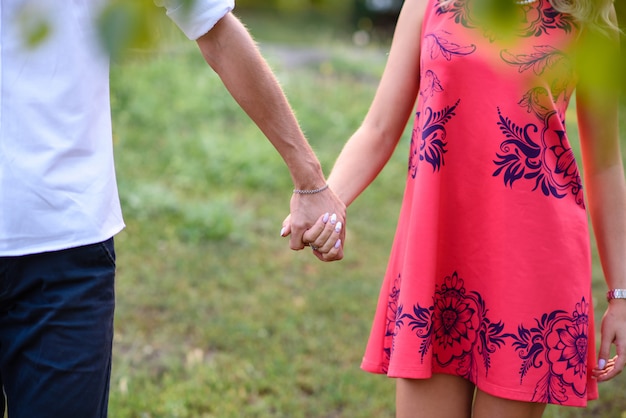 A man and woman in love walk in the park and hug.