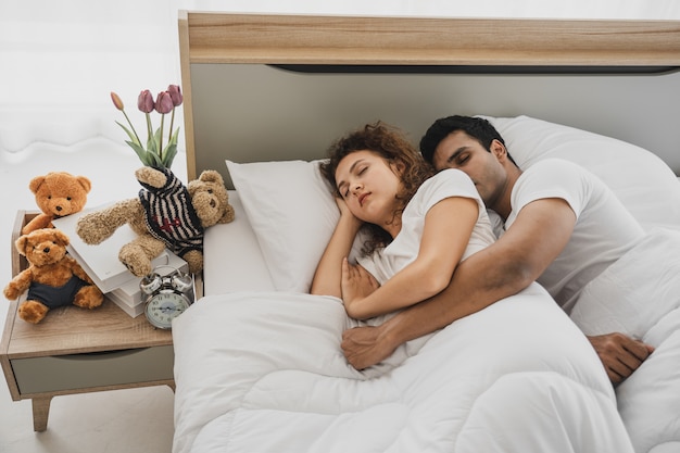 A man and a woman lying on a bed