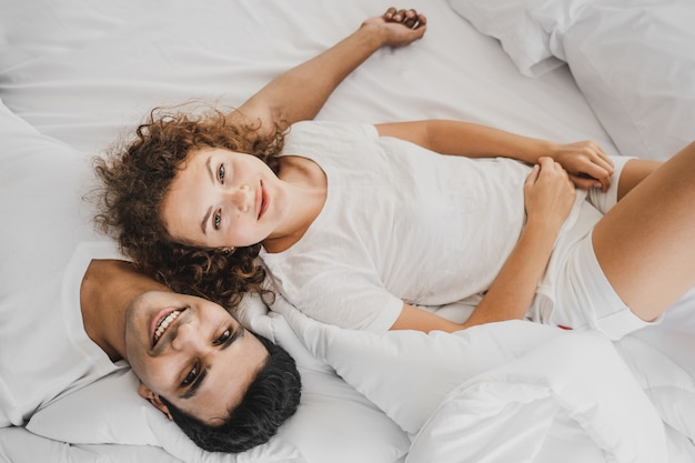 A man and a woman lying on a bed