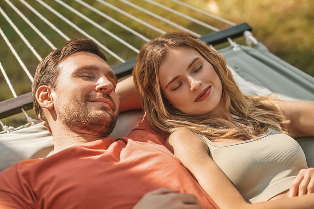 Man and woman napping in afternoon on hammock