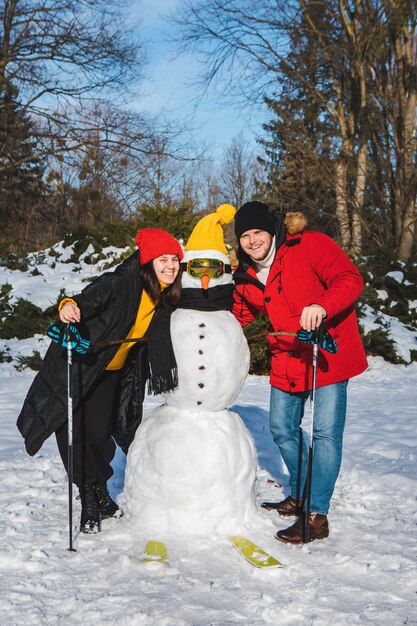 男と女の新しいスキーヤー雪だるま冬の活動