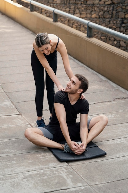 Man and woman outdoors exercising together