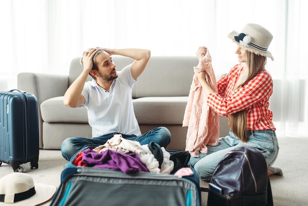 Man and woman packing their suitcases for vacation