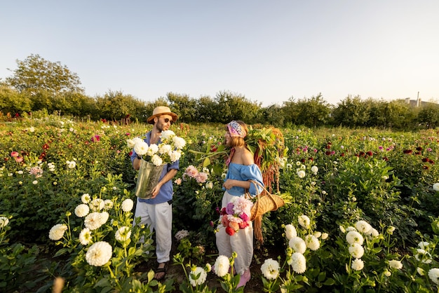 Man and woman pick up flowers at farm outdoors