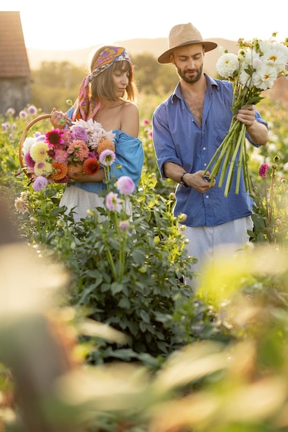 Man and woman pick up flowers at farm outdoors