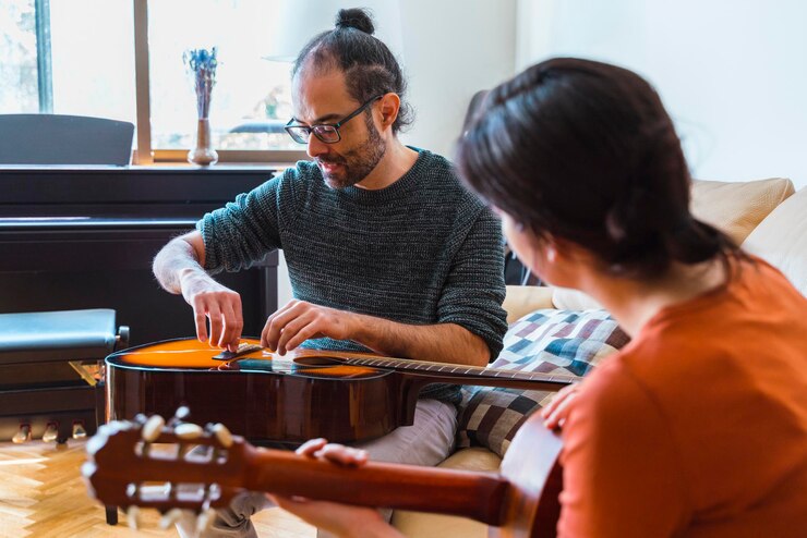 Photo man and woman playing guitar at home