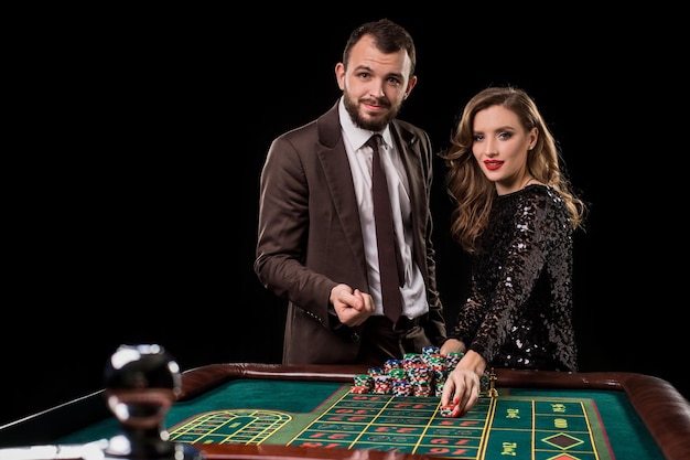 Man and woman playing at roulette table in casino