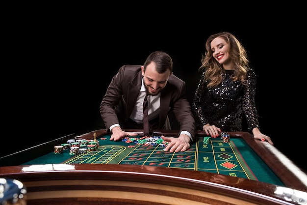 カジノのルーレットテーブルで遊ぶ男女