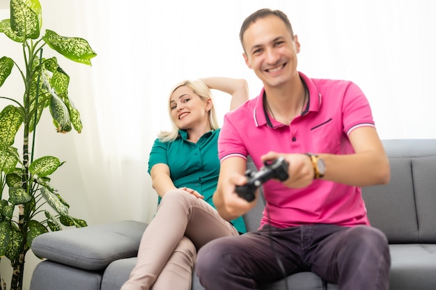 Man and woman playing video games with joystick at home.