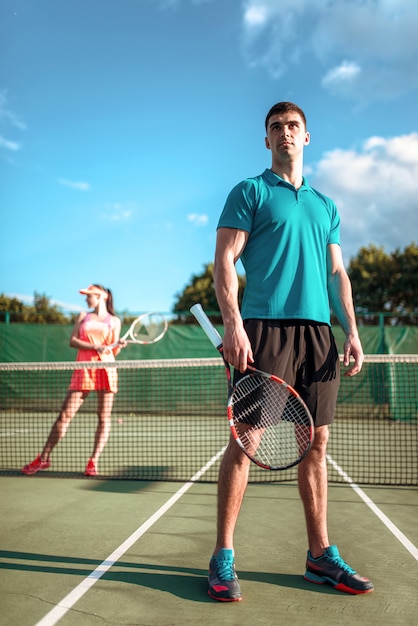 Man and woman plays tennis on open air.