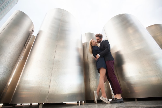 Man and woman pose in front of the large metal pipes