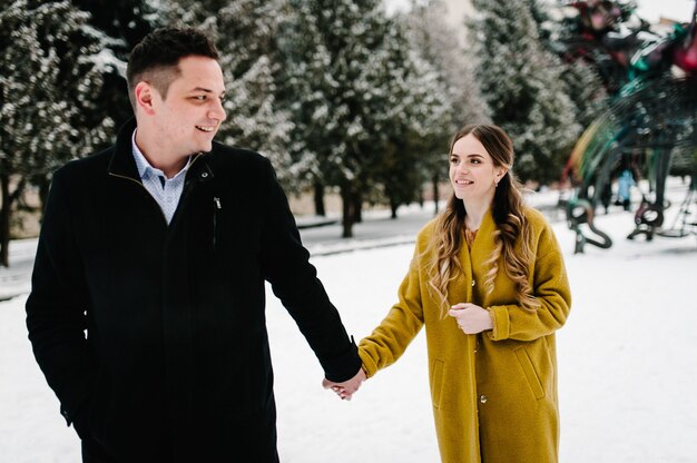 Man and woman posing outdoors in winter