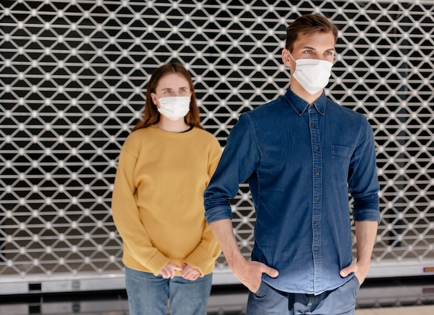 Man and a woman in protective masks standing at a safe distance . concept of health protection.