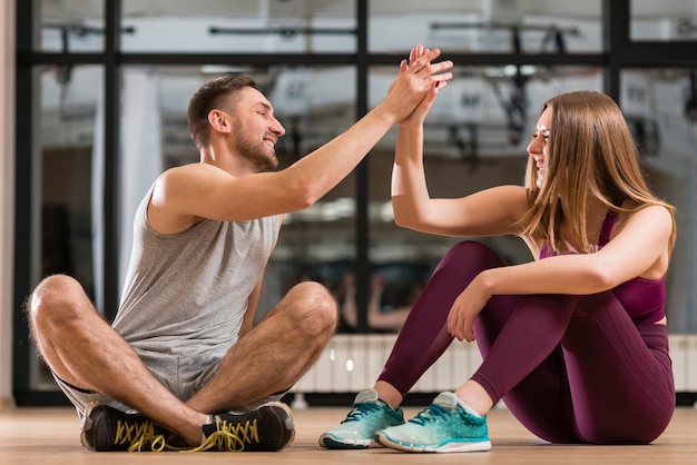 Foto uomo e donna orgogliosi del loro allenamento