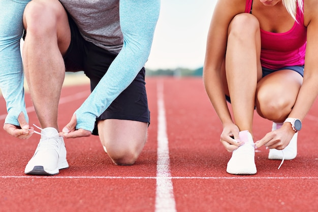 Uomo e donna che corrono su pista all'aperto