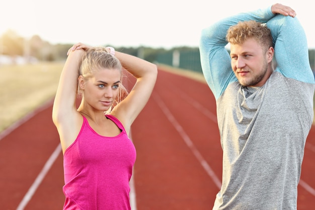 Uomo e donna che corrono su pista all'aperto