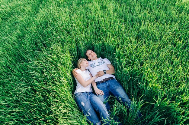 Man and a woman resting in green field.