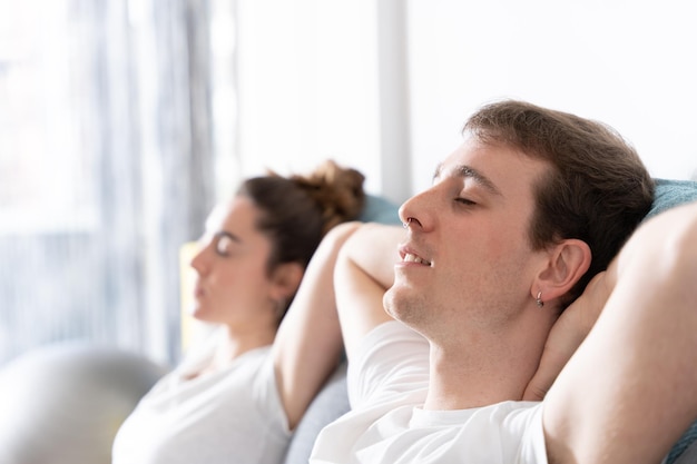 Man and woman resting with closed eyes on couch