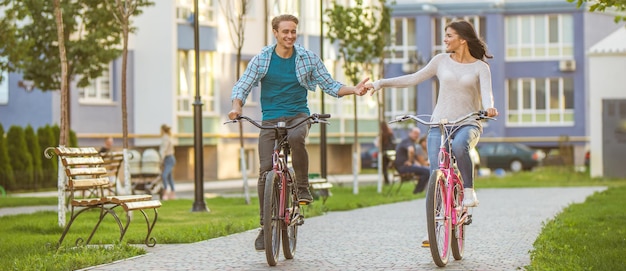 L'uomo e la donna in sella a una bicicletta in un parco residenziale