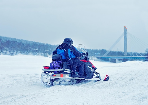 Man and woman riding snowmobile at winter Rovaniemi, Lapland, Finland