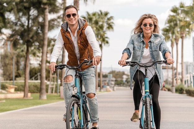 Photo man and woman riding their bikes outdoors