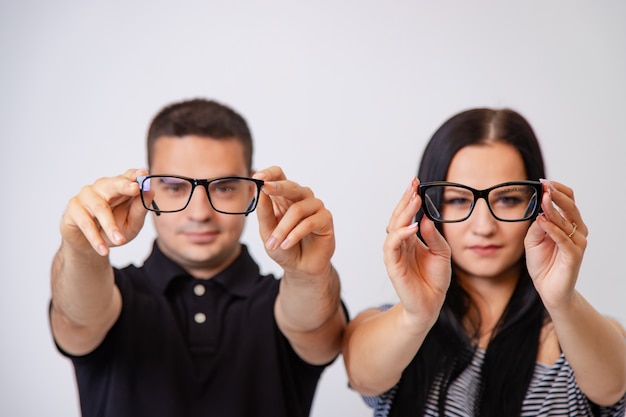 Man and woman show modern eyeglasses with black rims