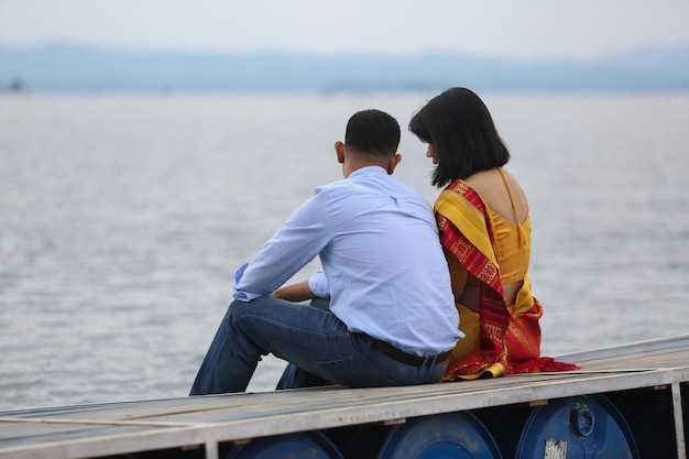 A man and woman sit on a boat looking out over the water