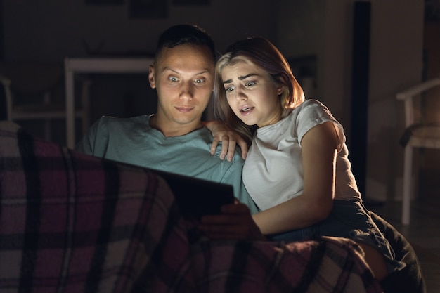 Man and woman sit at home in the evening