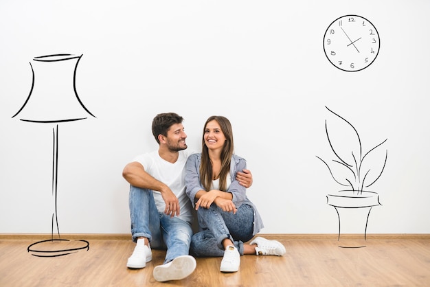 The man and woman sit near the wall with illustrations